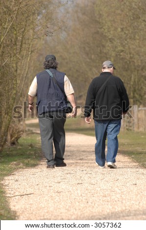two men walking away from view along a country track
