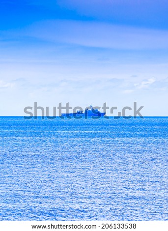 Cloudy blue sky above a battleship in the ocean