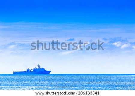 Cloudy blue sky above a battleship in the ocean