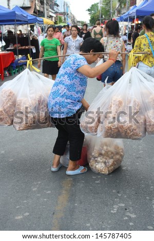 CHIANG MAI,THAILAND-JUNE 23 : career of sale of native snack for any vendor & tourist as mobile snack shop throughout Sunday walking Str., It is convenience .,On June 23, 2013 in Chiang Mai, Thailand.