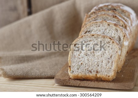 whole grain bread on wooden plate place on jute cloth. whole wheat bread.
