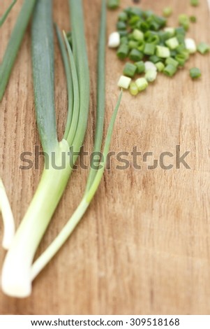 spring onion, chopped spring onions on wooden chopping block