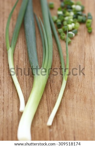 spring onion, chopped spring onions on wooden chopping block