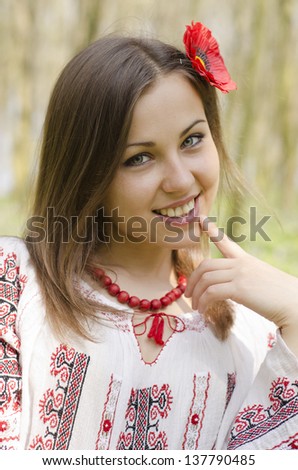 Portrait of  beautiful smiling girl with flower of poppy in hair