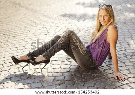 Portrait of a beautiful, attractive, young girl on paving background
