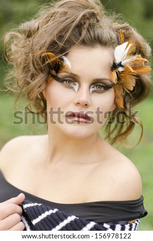 Portrait of a beautiful, charming and pretty girl with art makeup in modern fashion style