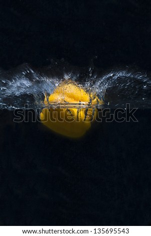 Yellow pepper splashing into water