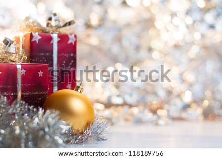 Christmas ball and gifts on abstract light background