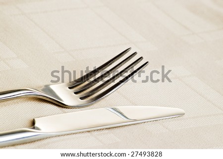 fork and knife on beige table cloth