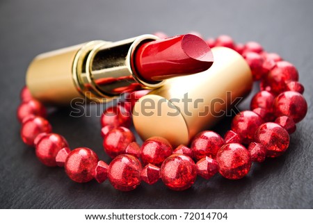lipstick and red  jewelry on black with shallow depth of field