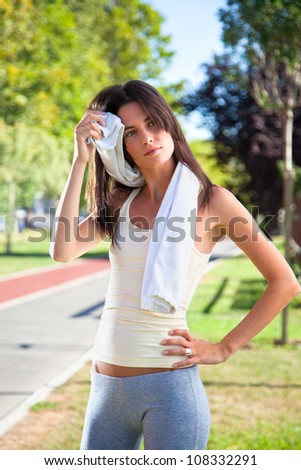 Beautiful young woman cleaning her sweat with a towel after sport
