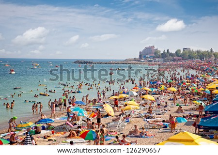 COSTINESTI, ROMANIA - AUGUST 6: Crowded beach with tourists in summer on August 6, 2012 in Costinesti, Romania. Costinesti is a famous summer destination for hundred of thousands of tourists a year.