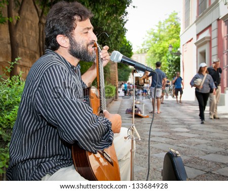 SEVILLE, SPAIN - SEP 11: Male musician playing in the street for money on Sep 11, 2011, in Seville, Spain. Spain is going through economic hardship these days.