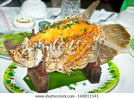 Fried fish prepared in the traditional Vietnamese way on banana leaves