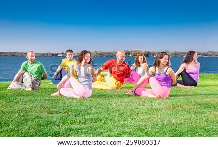 Young people practice Yoga asana on lakeside. Yoga concept.