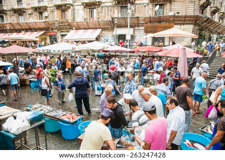CATANIA, ITALY- SEP 17,2014: Sellers and byers on the famous fish market in Catania on Sep 17, 2014, Italy. This market is also tourist attraction in Catania, Sicily.