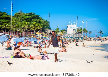 RIO DE JANEIRO, BRAZIL - APRIL 24, 2015: Young Brazilian waiter carrying drinks on April 24, 2015 at Ipanema Beach, Rio de Janeiro. Brazil.
