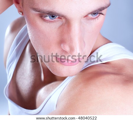 Close up Shot of a macho Man with blue eyes. A trendy European man dressed in contemporary cloth.