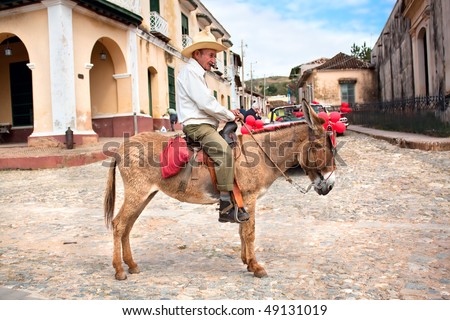 TRINIDAD, CUBA - JANUARY 14: Old men with cigar and donkey for rent in Trinidad. Working in tourism is the only way Cuban people can earn a decent income, on January 14, 2010 in Trinidad, Cuba.