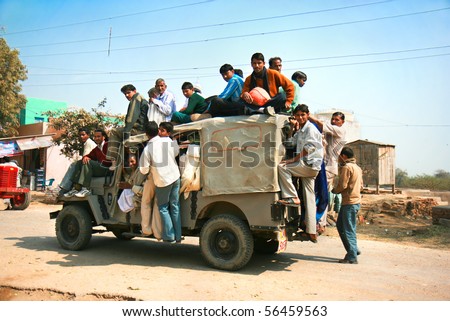AGRA, INDIA - FEBRUARY 22:  Public transport in India .Crazy road scene -truck with many people.   February 22, 2008. , Agra,  India.