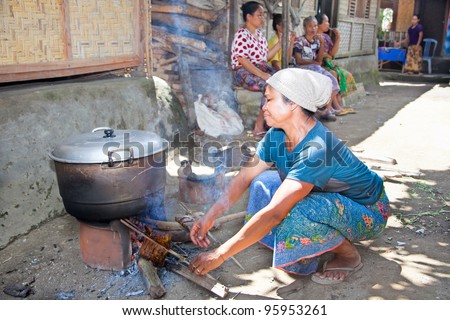 LOMBOK, INDONESIA-FEBRUARY 14: Woman makes Indonesian food on traditional way on February 14, 2012 in Sade village, Lombok, Indonesia.They always cooking food in open fire in front of the house