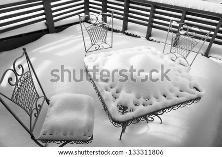 A snow covered table for three at winter morning.