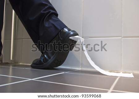 A stock photo of toilet paper stuck to the sole of a dress shoe