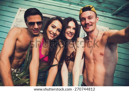 Multiracial group of friends taking selfie self-portrait at beach house at seaside