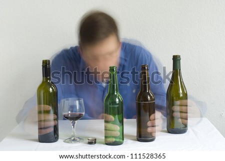 Man with bottles on the table. Blurry movement.