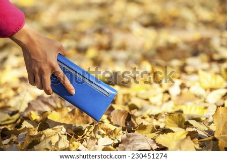 Young woman purse wallet on autumn background