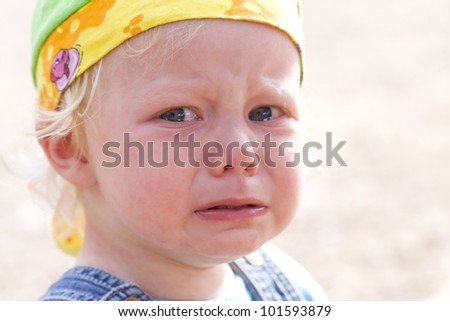 Close-up picture of a cute baby girl in angry tears.