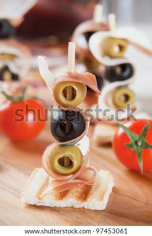 Delicious canape with pickled olives and italian prosciutto