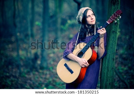 Girl with a guitar in the impressive light