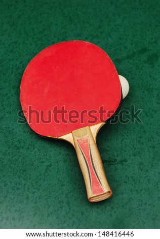 Racket and ball for playing table tennis on green background