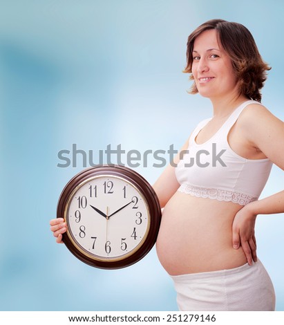 Pregnant woman with clock on a white background