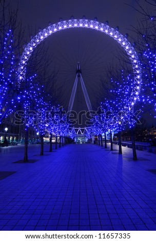 Pavement to London Eye, big wheel the famous symbol of London at night in purple color