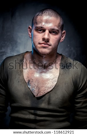 Portrait of muscular young man with dirty face and chest