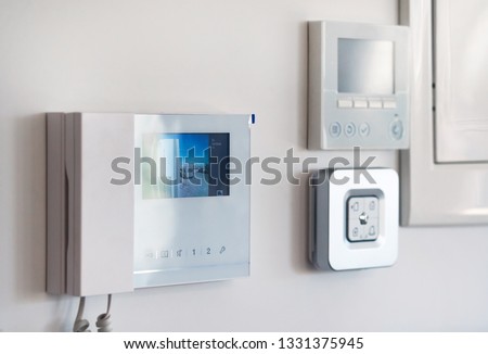 Concept of home automation smart modern luxury wealthy home. On white wall home security alarm and video intercom with street view talkback or doorphone voice communications system close up, no people