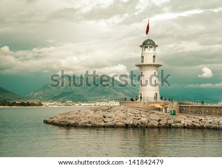 Beautiful nature landscape with mountains range, cloudy sky and lighthouse in port Alanya, Turkey