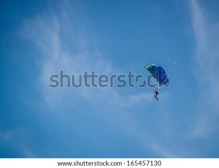Parachutist over sky background