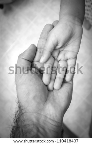 A Men's hand holding Child hand or helping hand concept with vignette. Charity concept. Providing support.