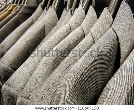 Row of men\'s suit jackets hanging in a supermarket department store.