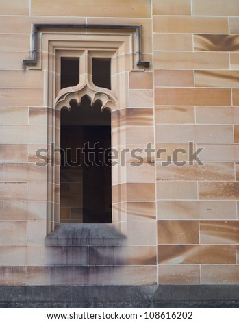 A gothic window on a sandstone wall.