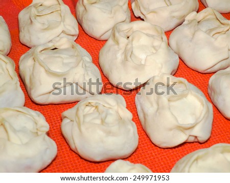 Raw Asian second dish of dough and meat, which is steamed. Manti with stuffing.