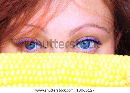 Part of a woman\'s face. Big blue eyes, and corn husks under them.