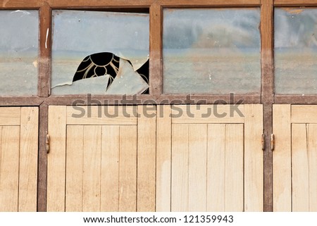 The closeup image of the broken glass window and wooden windows