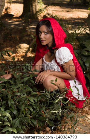 Adult woman dressed up in Red riding hood costume in the woods
