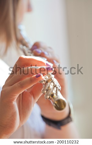 Hands girl playing a flute closeup in sunlight