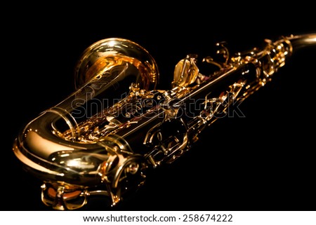 Lying saxophone on black background in dark colors