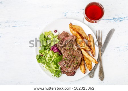 Grilled Rib-eye Beef Steak with Green Salad and Herb Potato Wedges